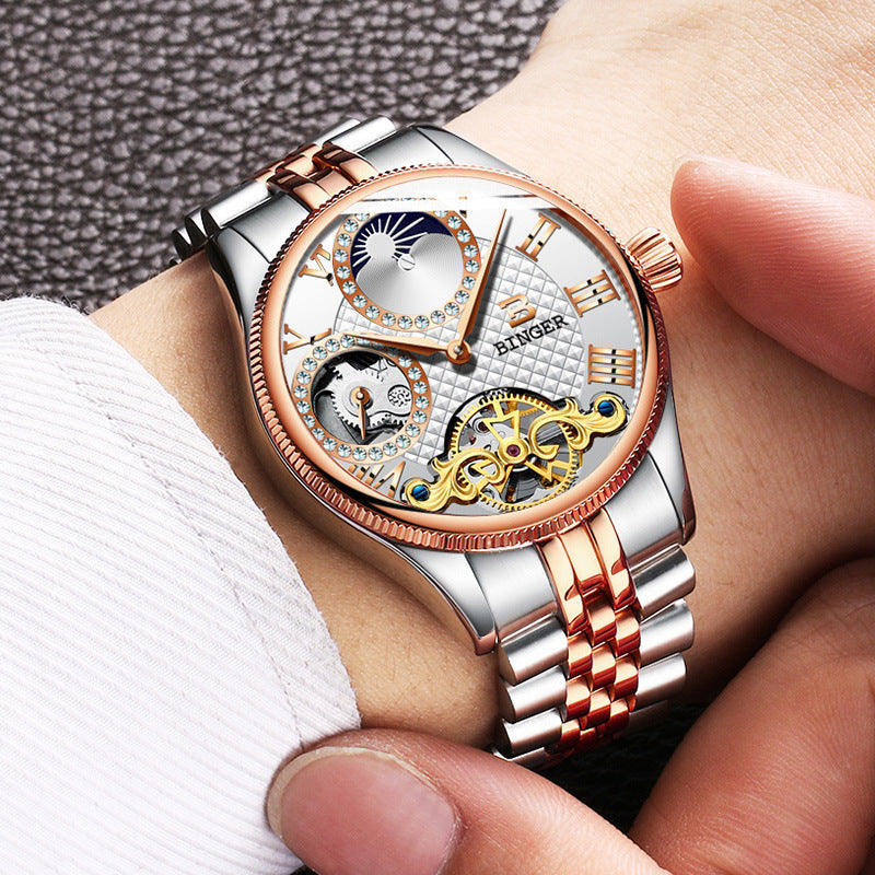Men's automatic mechanical skeleton watch with stainless steel band and rose gold accents on wrist
